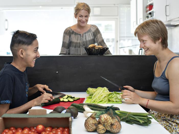 To studerende deltager laver mad med en underviser.