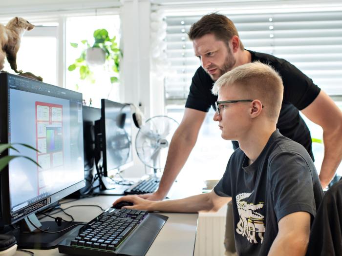 Underviser hjælper en studerende ved en computer i Medie.