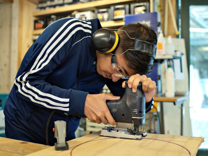 Studerende bruger stiksav i værkstedet.