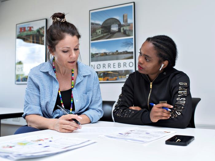 Underviser hjælper studerende med faglig undervisning.