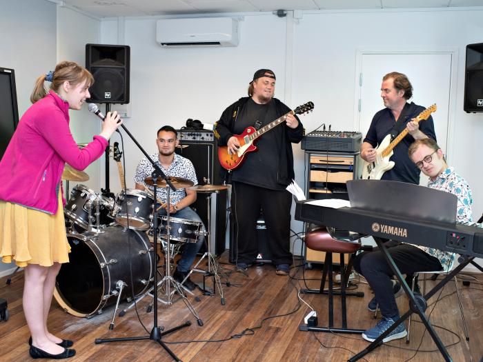 Fire studerende spiller sammen i et band.